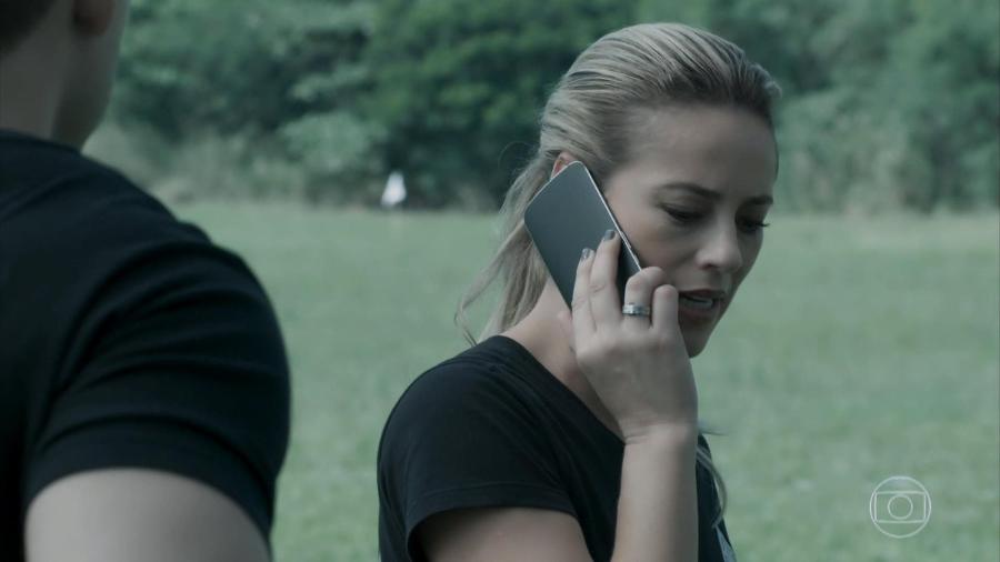 Policial fala com celular ao contrário (Reprodução/TV Globo)