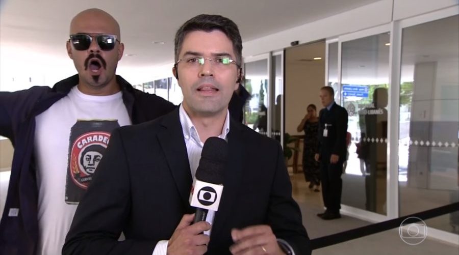 Repórter Bruno Tavares no Jornal Hoje sendo interrompido por manifestante