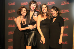 Bate-papo Tá no Ar - Renata Gaspar, Veronica Debom, Georgiana Góes e Luana Martau com foto de Carol Portes, que está de licença-maternidade, no celular.