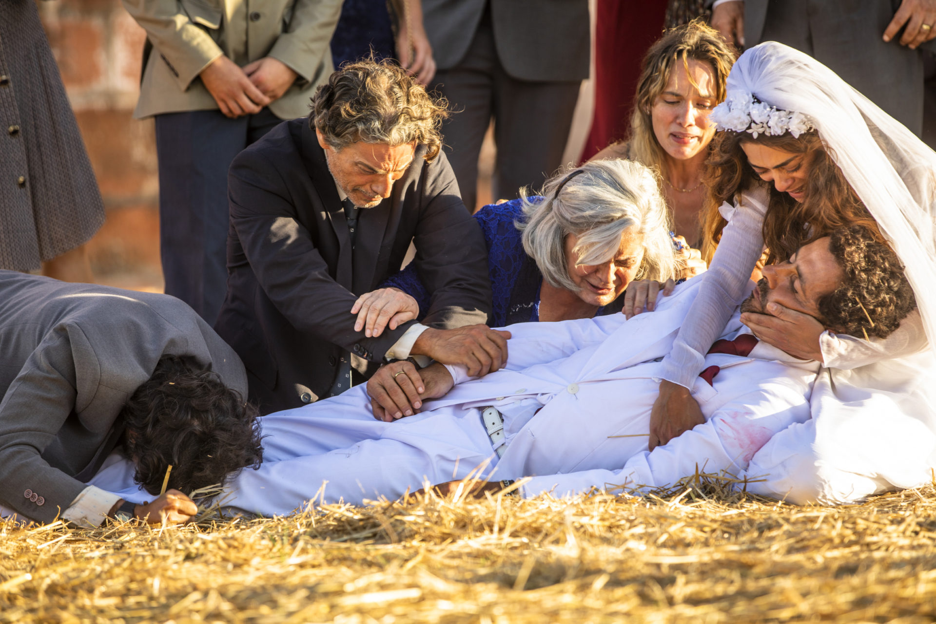 Maria Da Paz (Juliane Paes) e Amadeu (Marcos Palmeira) no chão. Miroel (Luiz Carlos Vasconcellos), Nilda (Jussara Freire), Vicente (Álamo Facó) e Ticiana (Áurea Maranhão) com eles em A Dona do Pedaço