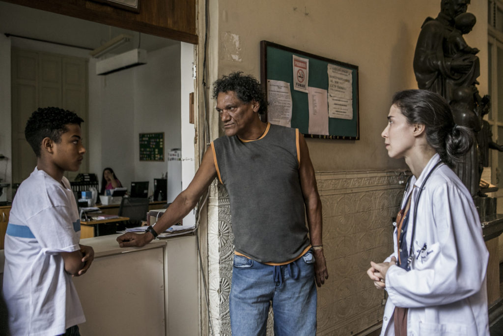 Wallace (Frabicio Assis) chega com o padrasto ao hospital e é recebido por Carolina (Marjorie Estiano) em Sob Pressão