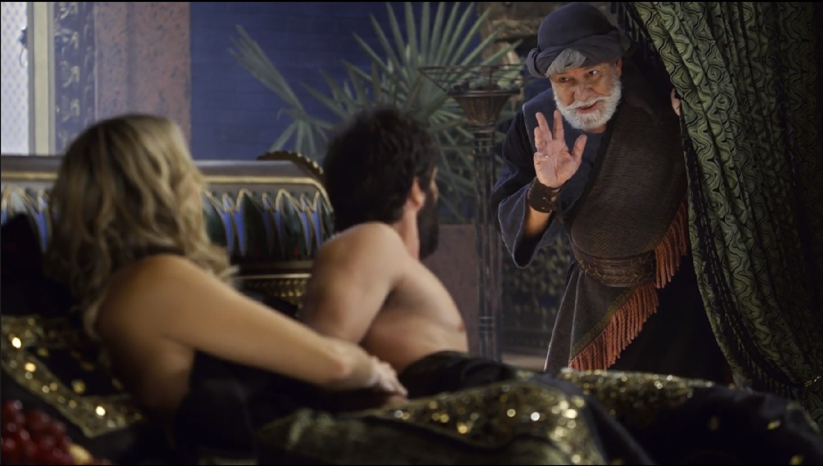 Zabaia (César Pezzuoli) flagra Sammu (Christine Fernandes) e Rabe-Sáris (Gustavo Leão) na cama em O Rico e Lázaro