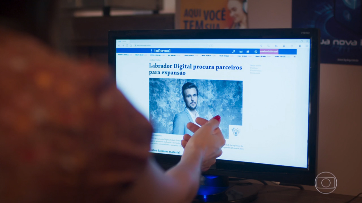 Kyra (Vitória Strada) vendo uma notícia de Rafael (Bruno Ferrari) em Salve-se Quem Puder