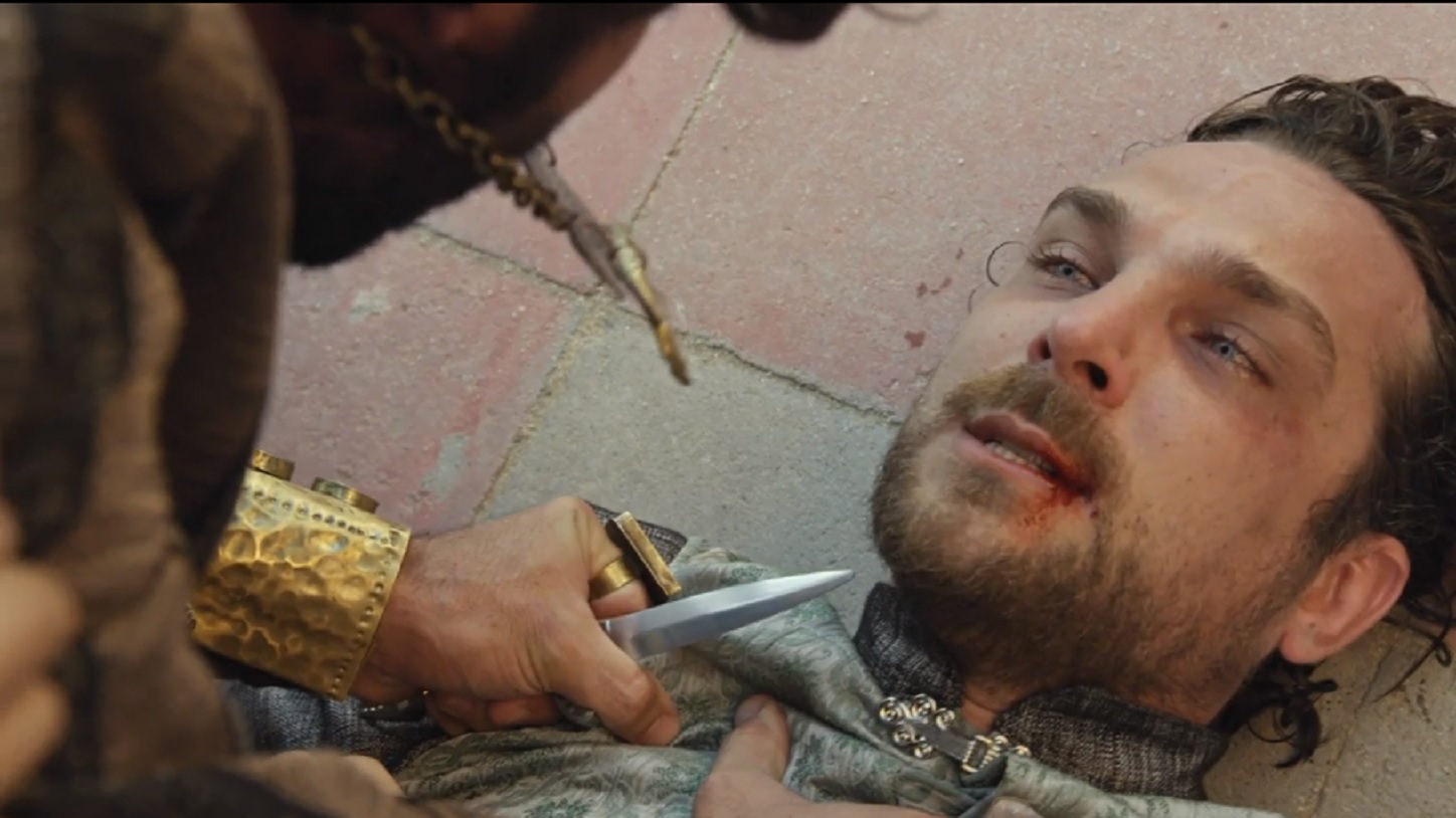 Asher (Dudu Azevedo) aponta um punhal no pescoço de Zac (Igor Rickl) em O Rico e Lázaro