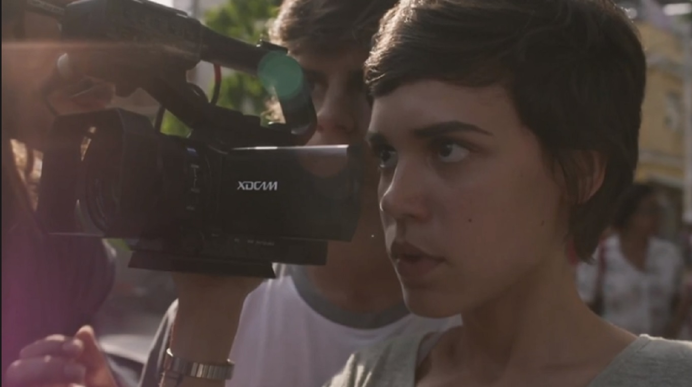 Leila (Carla Salle) filmando a acusação de policiais em Totalmente Demais