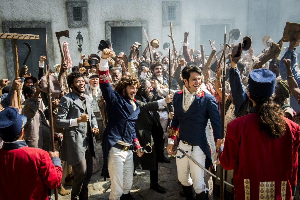 Pessoas vaiando Avilez ( Paulo Rocha ), que bate em retirada Dom Pedro ( Caio Castro ) no centro e Joaquim ( Chay Suede ) e Chalaça ( Romulo Estrela ) ao lado
