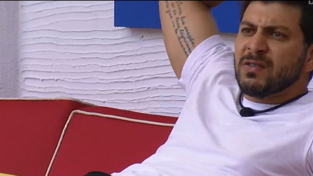 Caio na beira da piscina do BBB 21