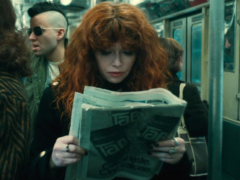 Indo para 1982, Nadia (Natasha Lyonne) lê um jornal da época