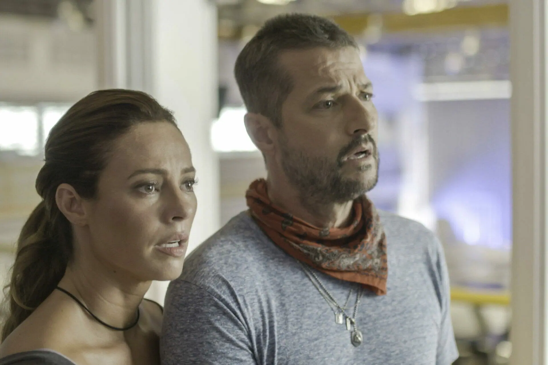 Moa (Marcelo Serrado) e Pat (Paolla Oliveira) diante da tv assistem perplexos reportagem sobre a morte de Clarice (Taís Araújo).