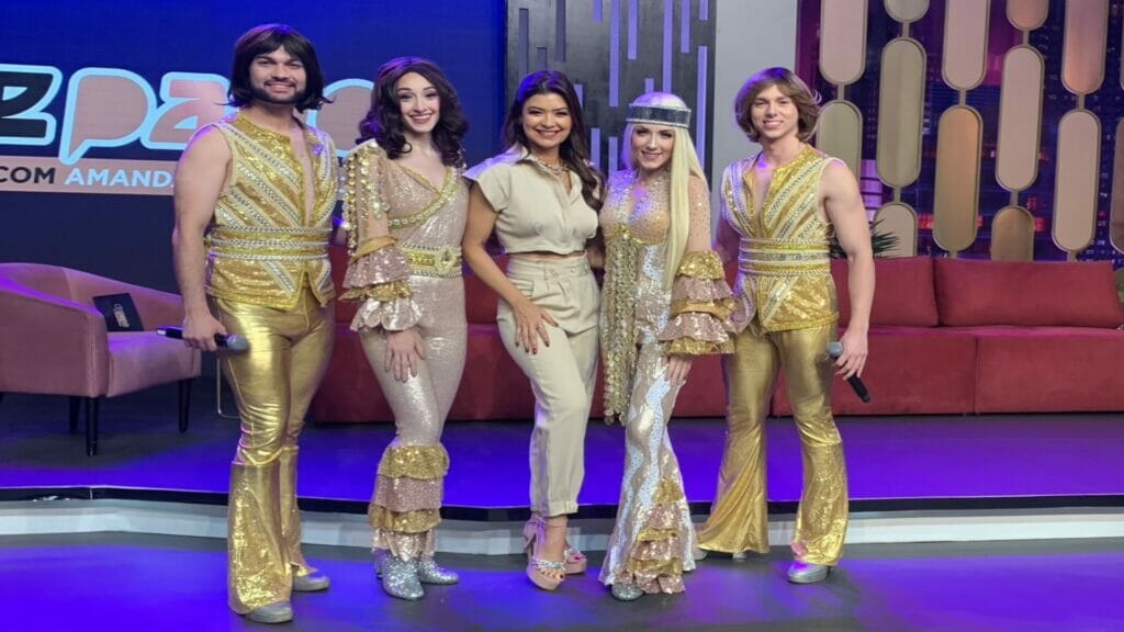 Amanda Françozo entre os integrantes do grupo Abba Experience In Concert