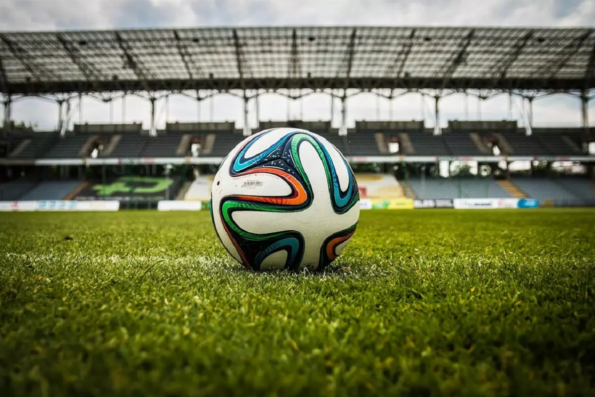 Bola de futebol multicolorida num estádio