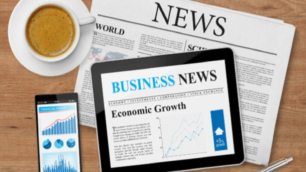 Típica mesa de café da manhã de quem lê jornal, com tablet, smartphone e xícara